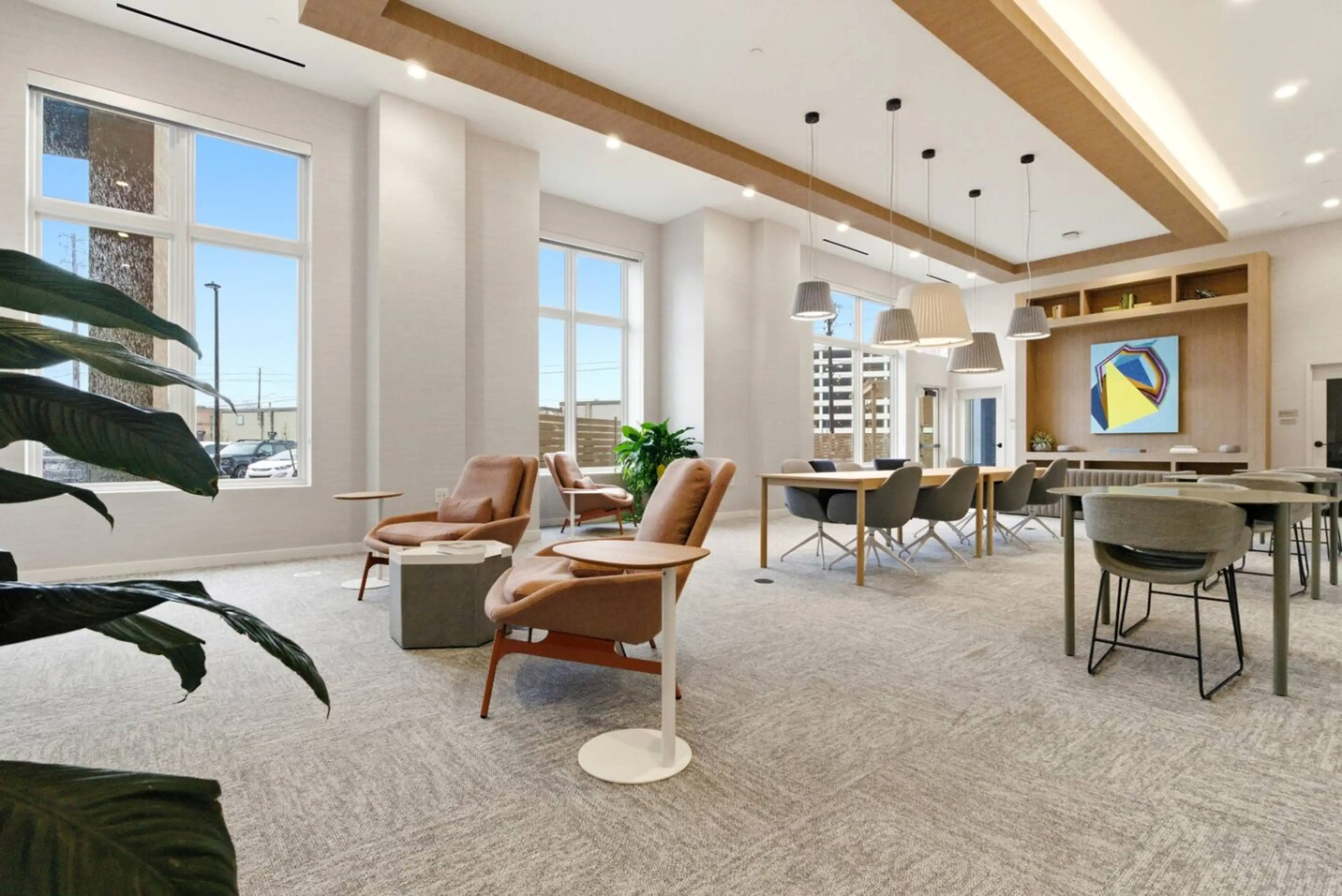 Open coworking room with long shared tables and task chairs in a Nearwell building