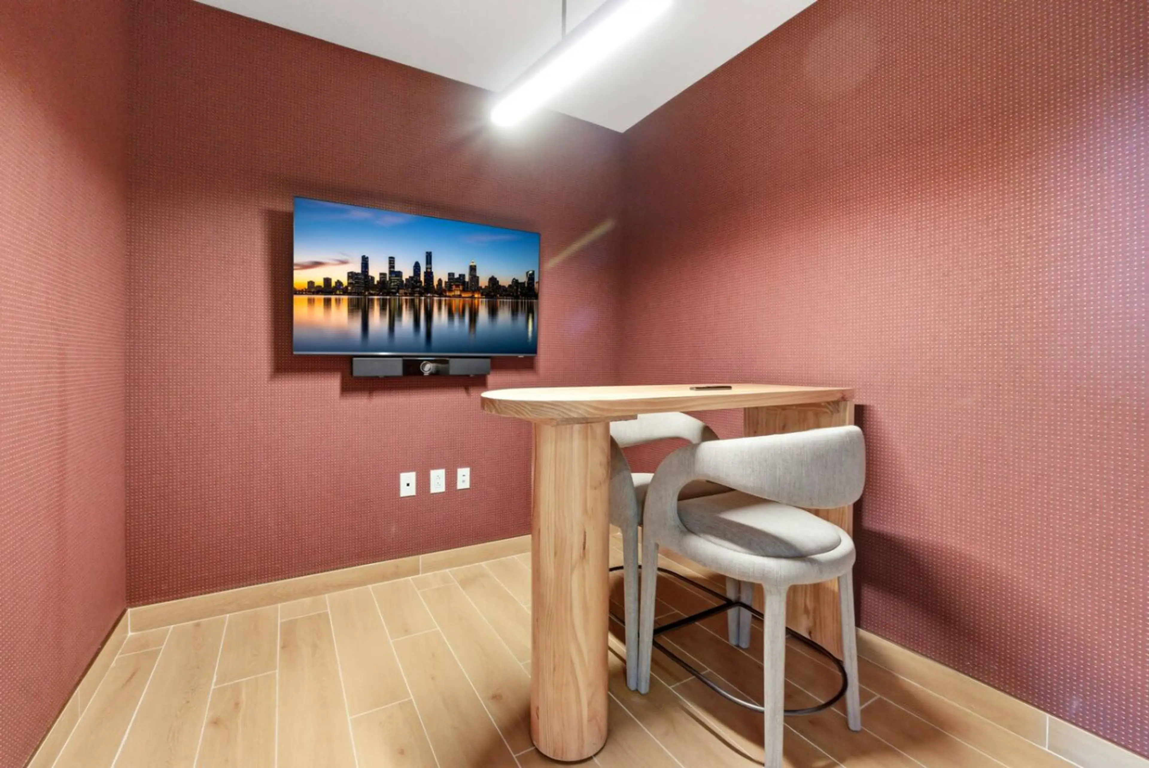 Small private meeting room with a high table, two chairs and a screen