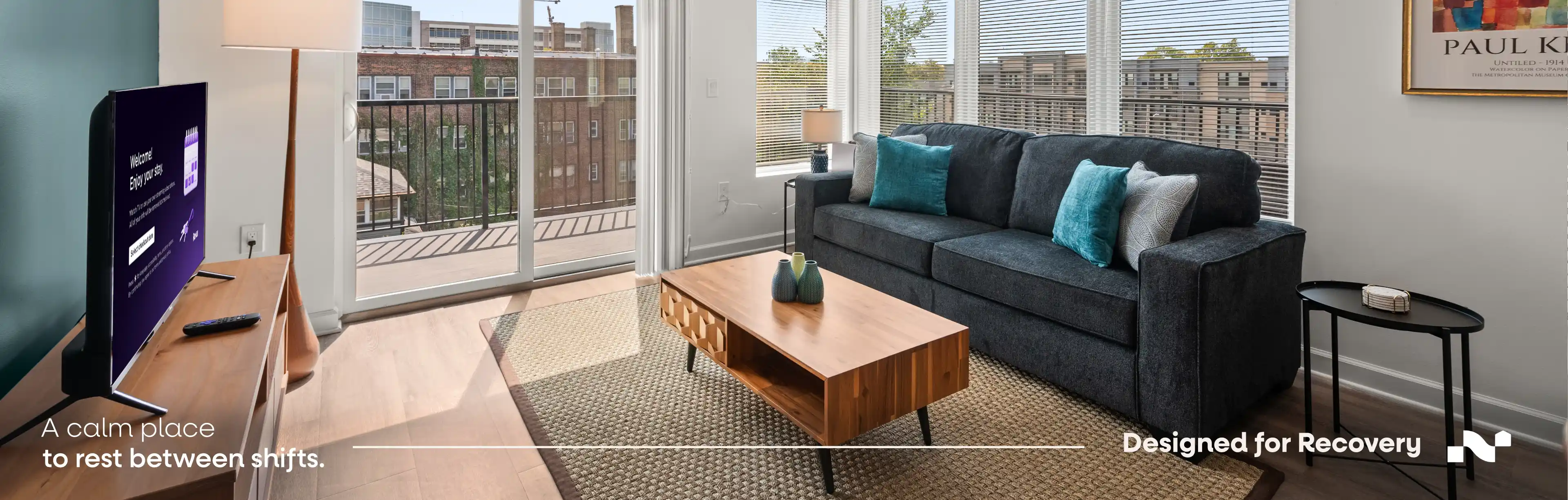Travel nurse resting with a coffee on the couch of a furnished Nearwell apartment near Cleveland Clinic at sunset.