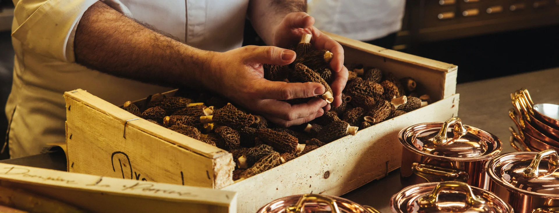 Chef travaillant les champignons en cuisine au restaurant Drouant