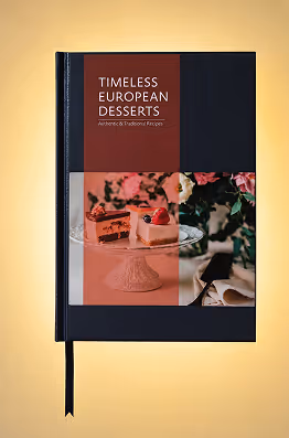 Cookbook titled Timeless European Desserts with photo of cakes on a glass stand and flowers.