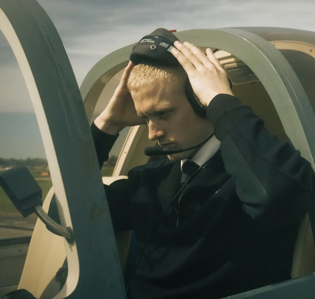 Pilotstuderende tager headset på i cockpittet