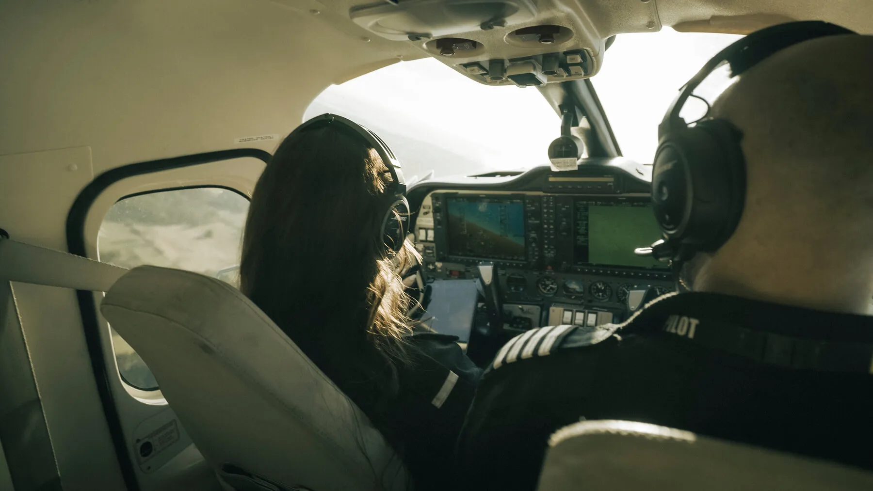 Pilotstuderende i cockpittet med headset under en træningsflyvning