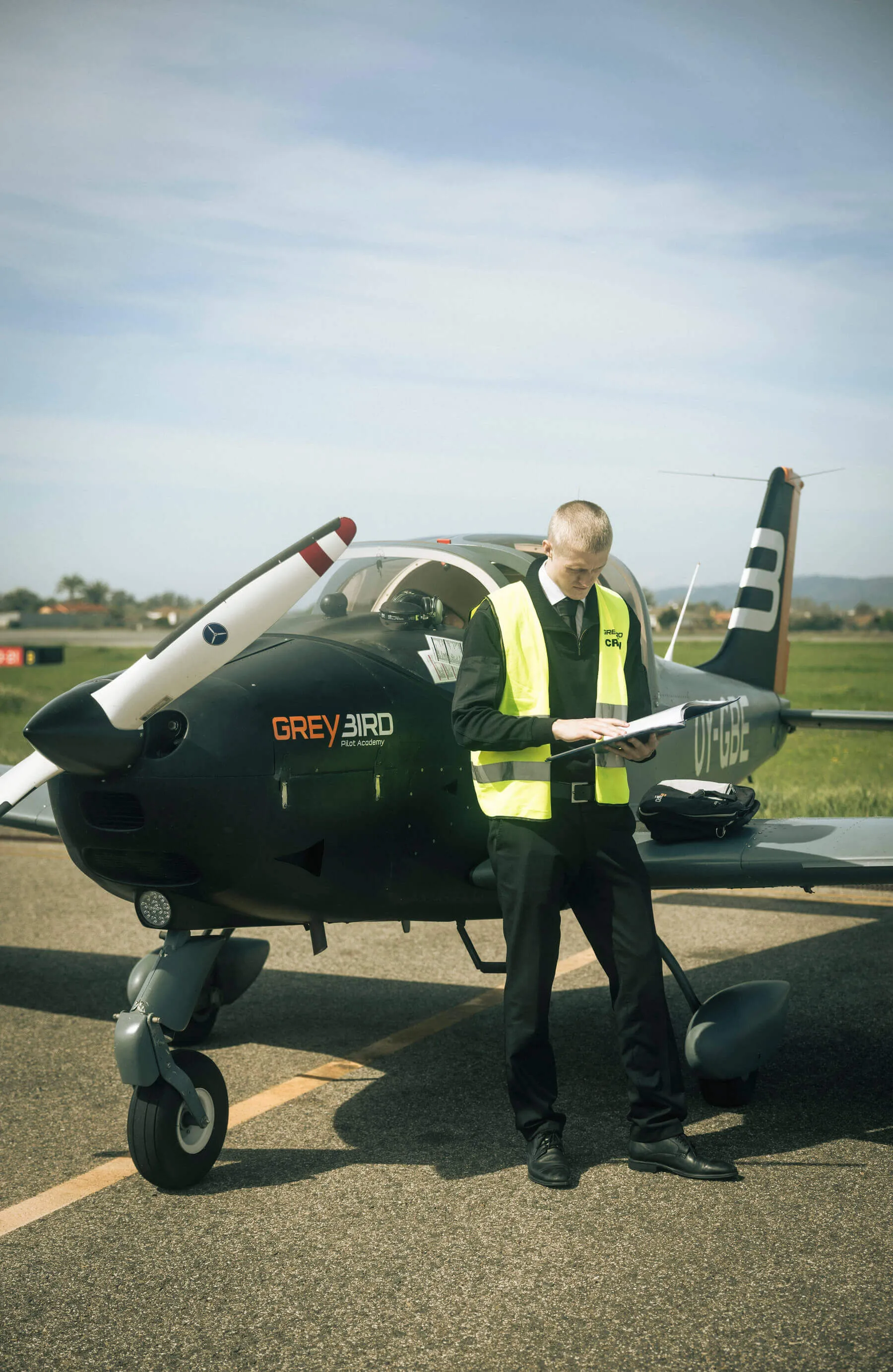 Greybird-kadet gennemgår en tjekliste foran et træningsfly