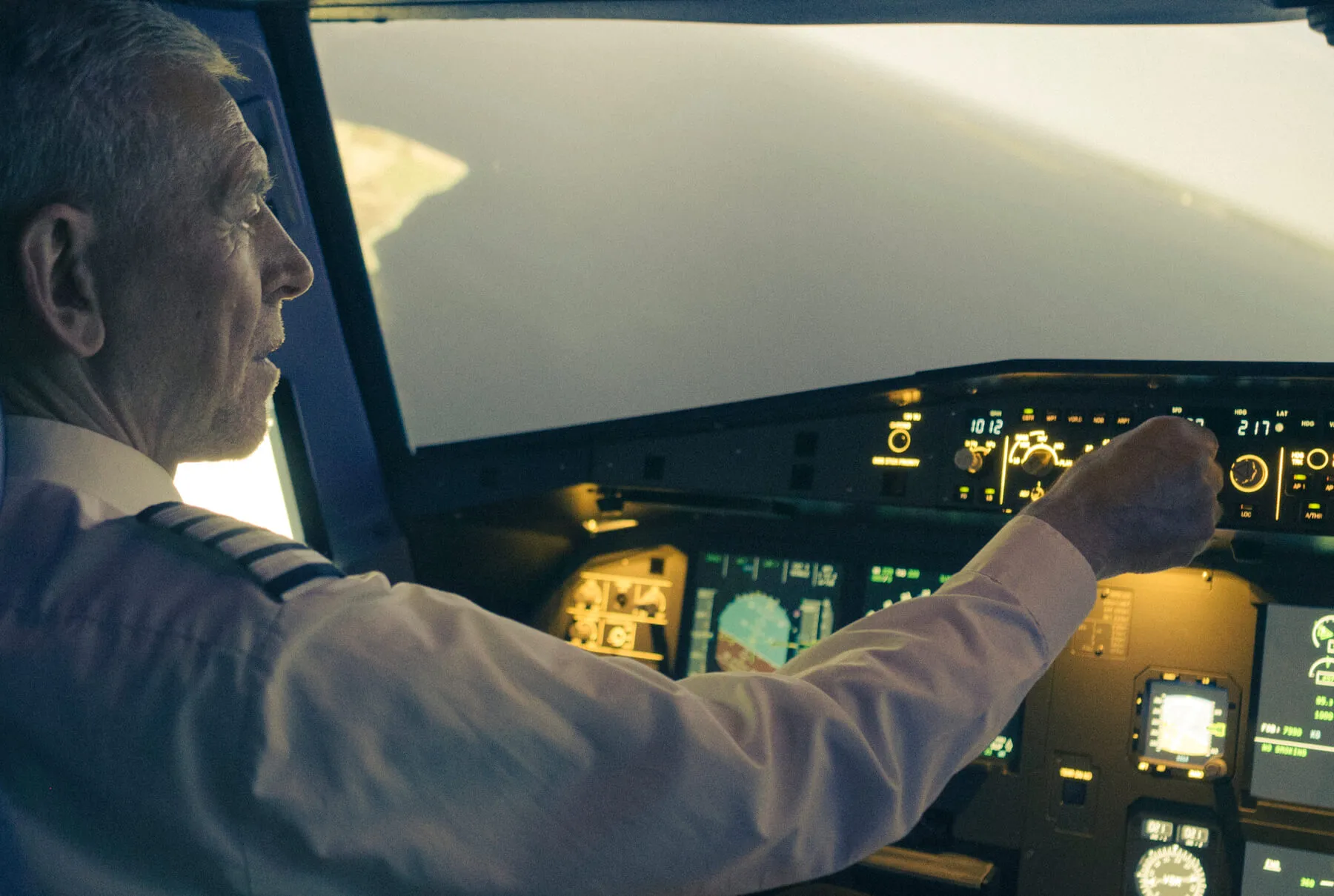 Pilot i en flysimulators cockpit rækker ud efter kontrollerne