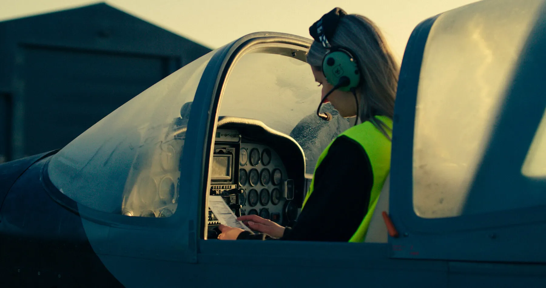 Kvindelig pilotstuderende i et lille flys cockpit gennemgår en tjekliste