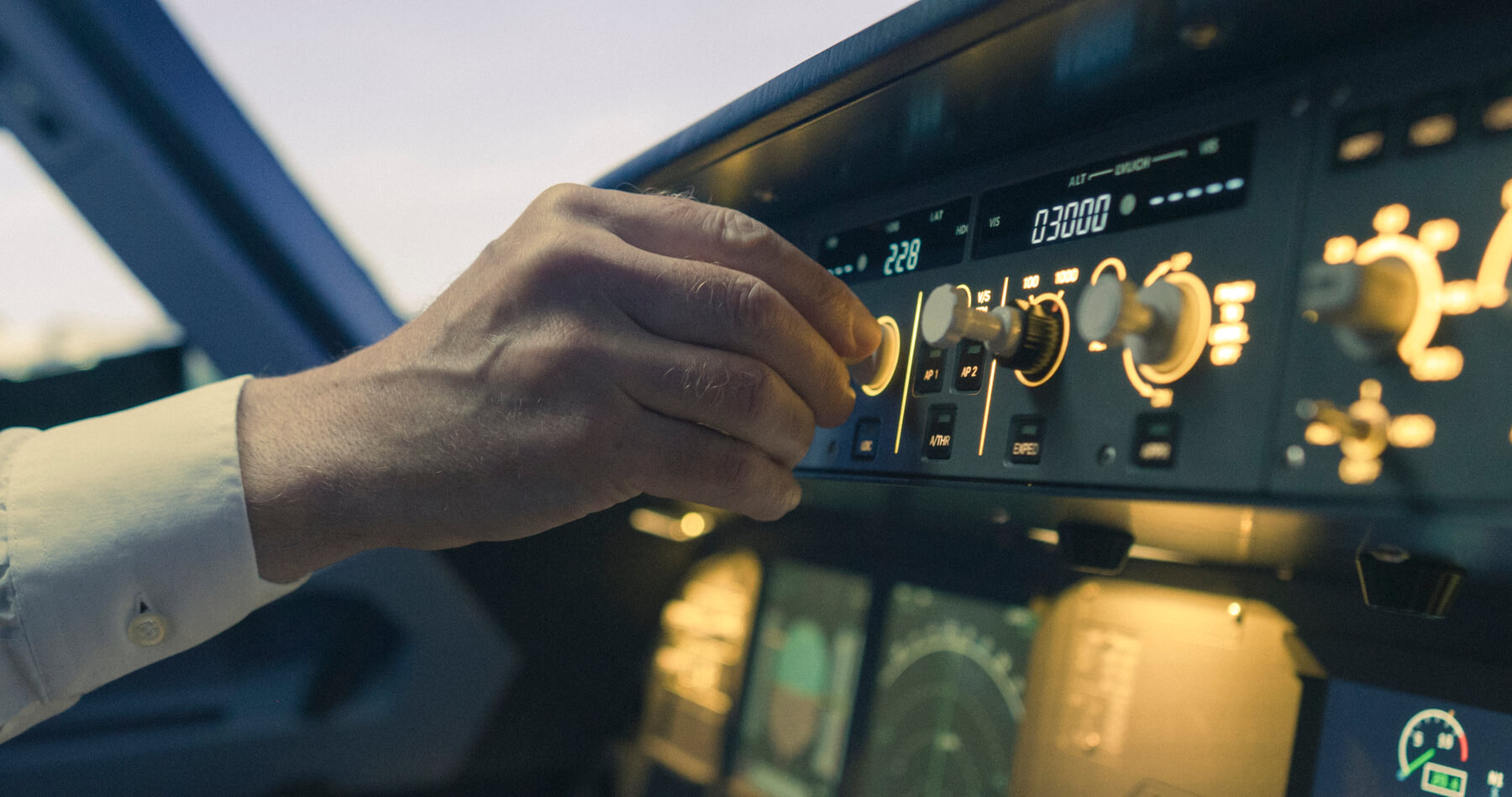 Captain's hand adjusting the autopilot control panel