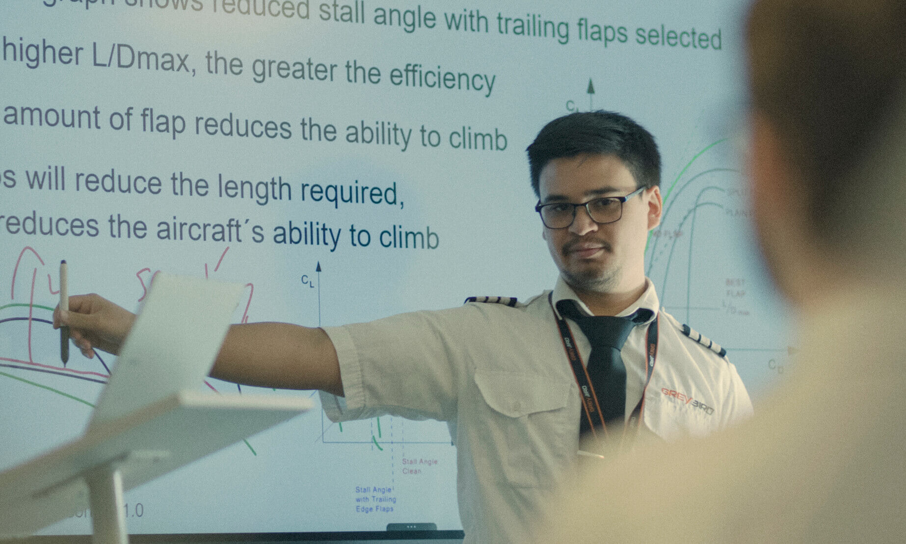 Greybird instructor explaining aerodynamics theory on a classroom screen