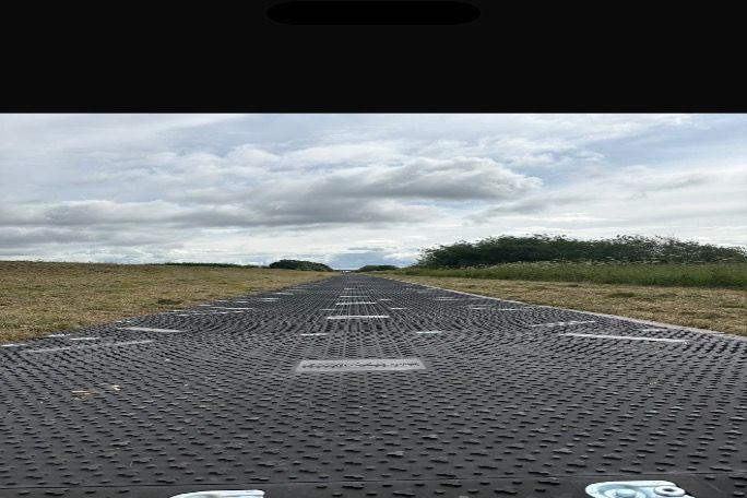 Heavy-duty temporary trackway panels laid out across the project site to create a stable access route for construction traffic.