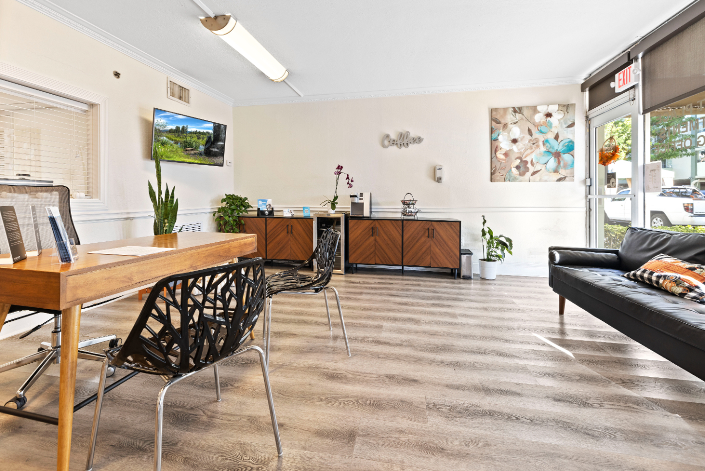 Lounge and leasing office with seating area, coffee bar, tv, and desk