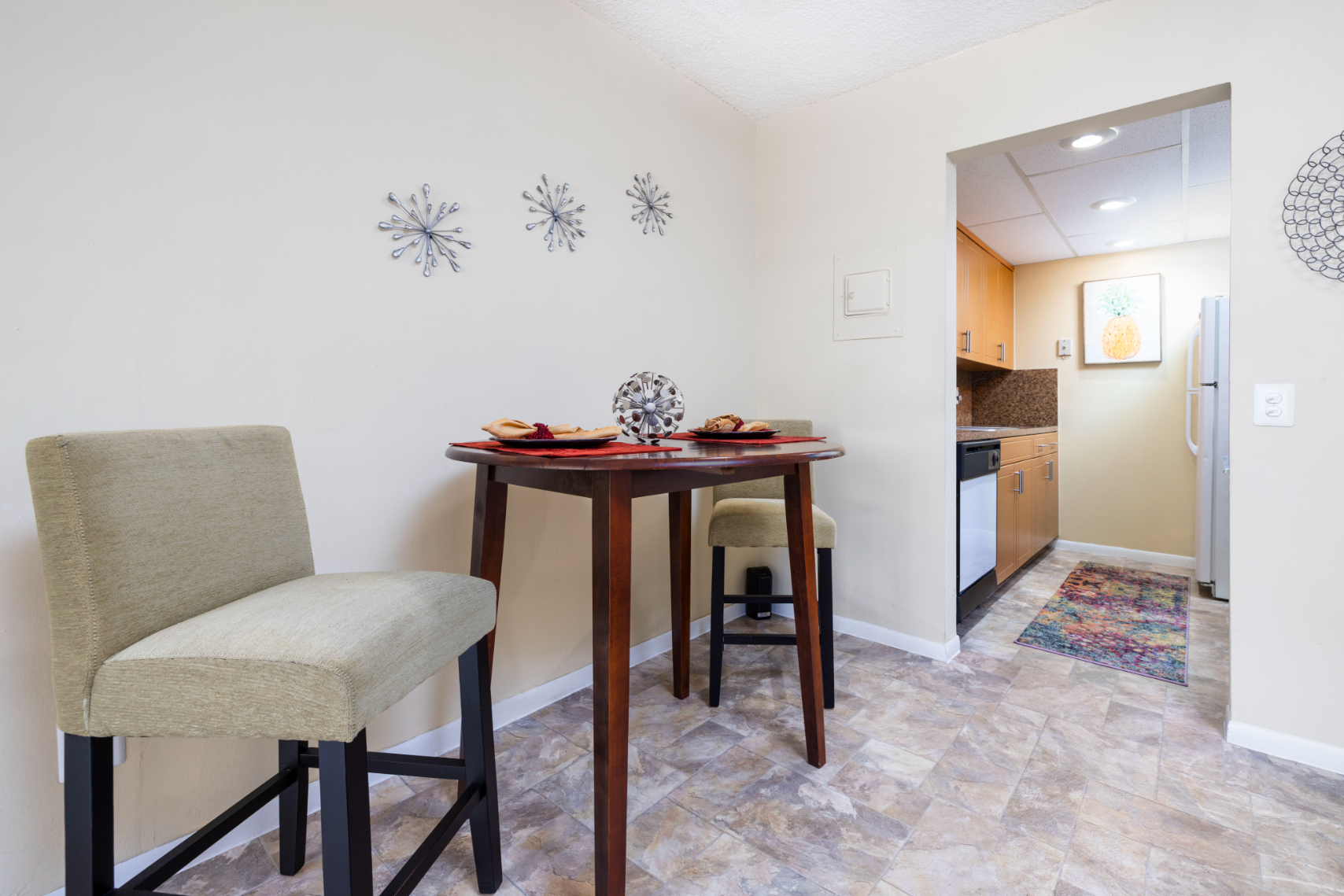 Wide view of dining area with table and chairs and kitchen