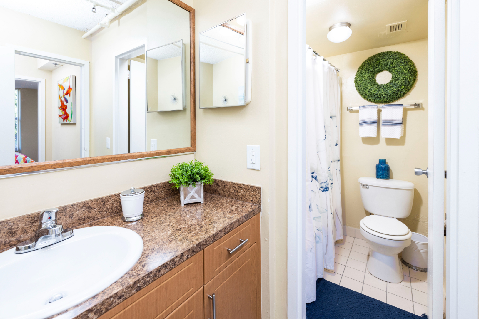 Bathroom with shower tub combo and brown cabinets