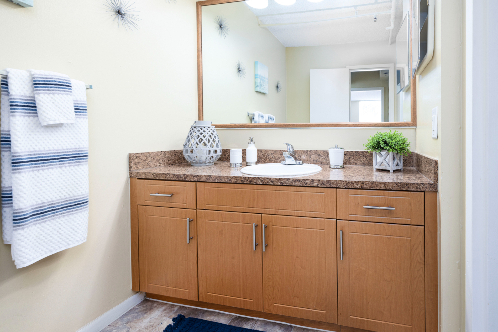 Bathroom vanity with mirror and brown cabinets