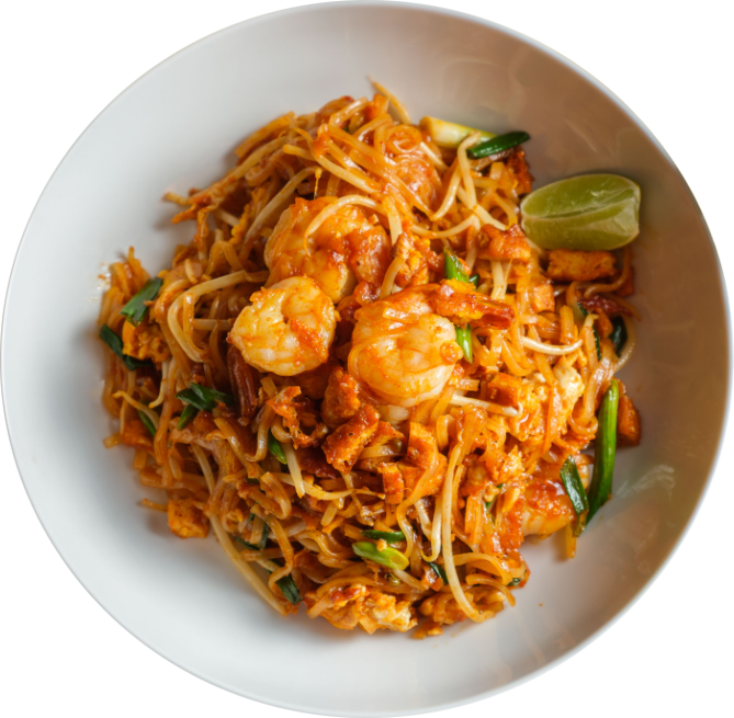 Plate of pad thai noodles with chicken, green onions, peanuts, and a lime wedge.