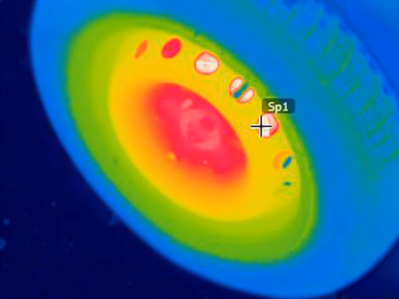 Thermal image of a car wheel showing heat distribution from red center to cooler blue edges.