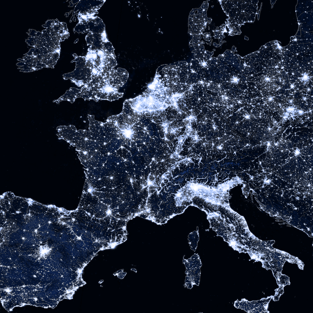 Satellite view of Europe at night showing illuminated cities and regions.