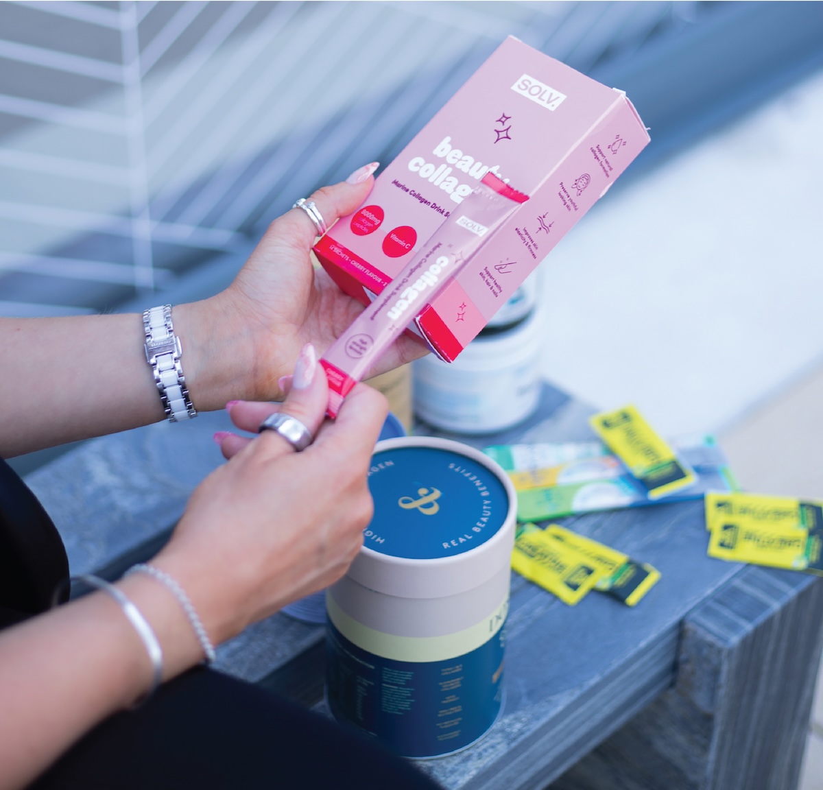 Hands holding client supplement and skincare products