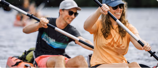 Kayakers paddling on a calm Kauai river during a guided tour.