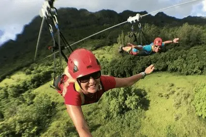 Guests flying prone on Hawaiʻi's longest FlyLine zipline over Kīpū Ranch.