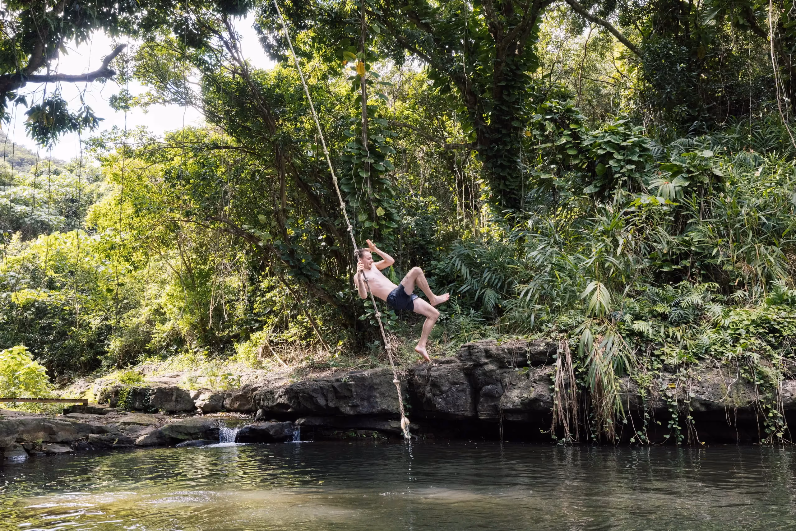 Guests kayaking on a calm Kauai river surrounded by tropical greenery.