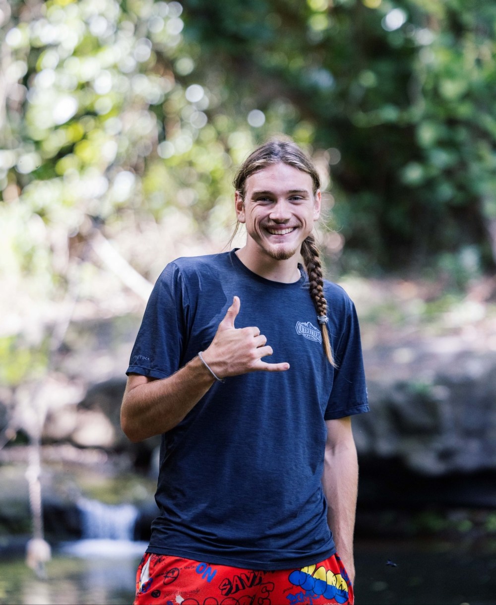Outfitters Kauai guide giving a shaka beside a stream on the Kīpū Safari tour