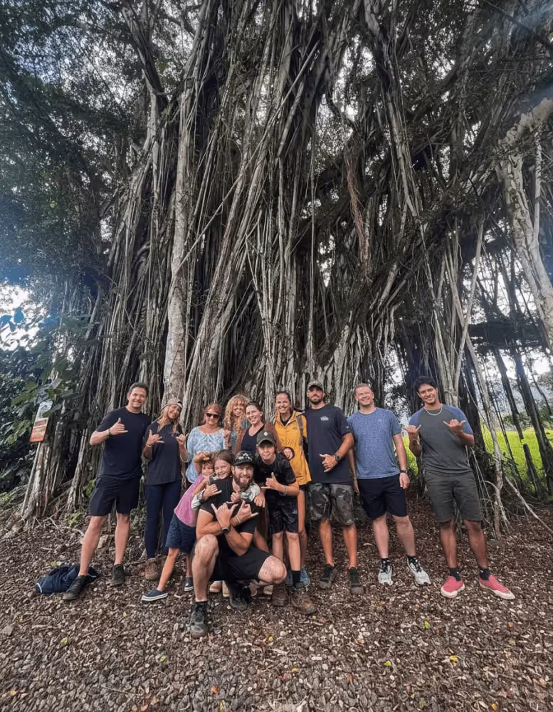 Family in front of large banyan tree on Kipu Ranch after their Zipline Tour with Outfitters Kauai.