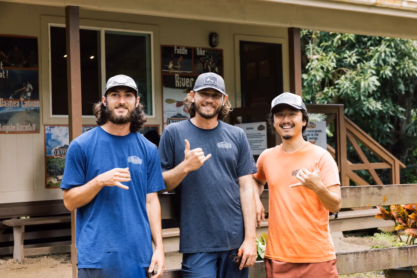 Three experienced Kauai adventure guides smiling in front of tour office building
