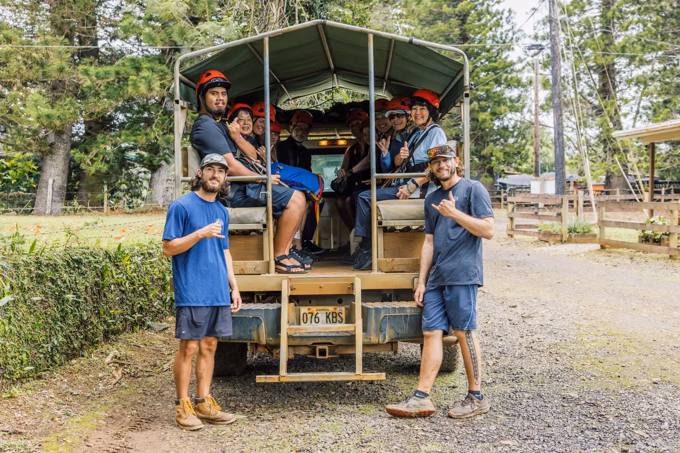 Kauai tour guides standing beside jungle transport vehicle used for zipline tour access