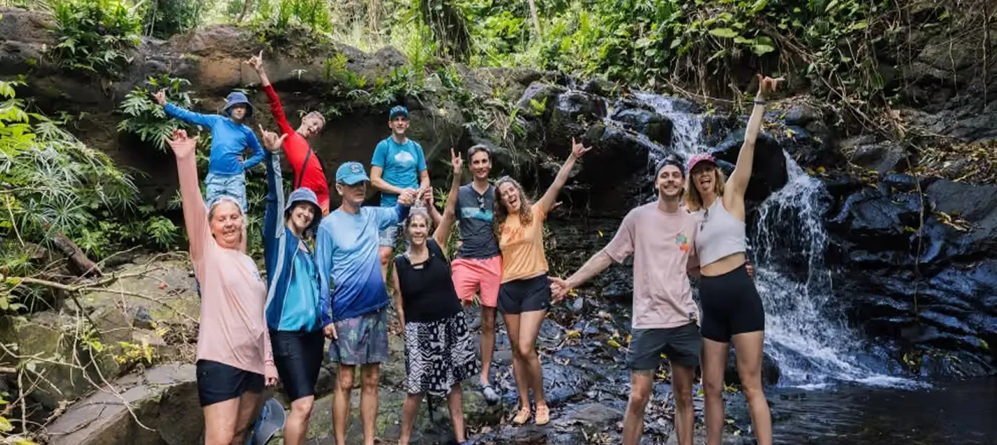 Tour group cheering at Hidden Valley Falls on the Huleʻia River kayak and hike