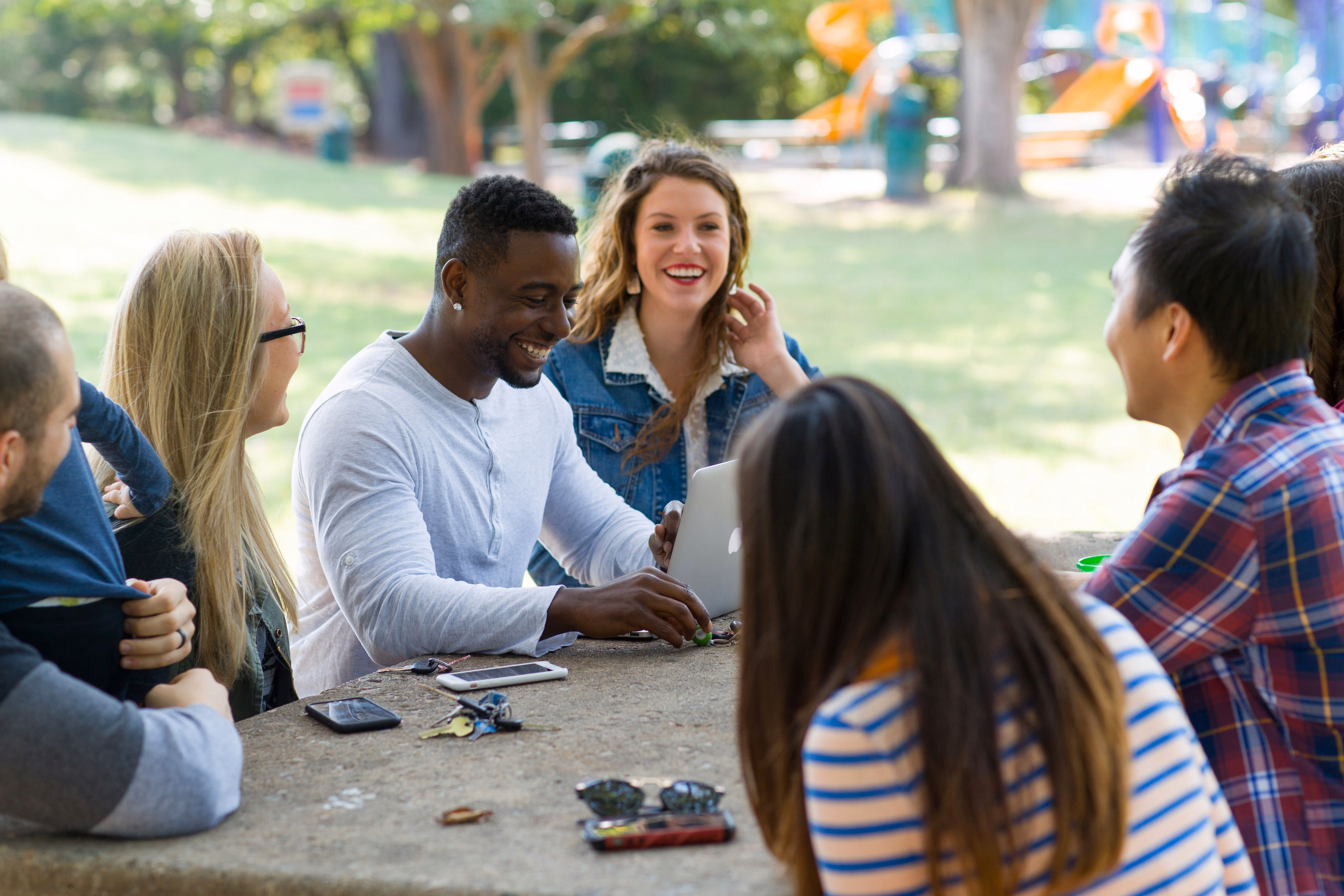 Four student sit on bench on park