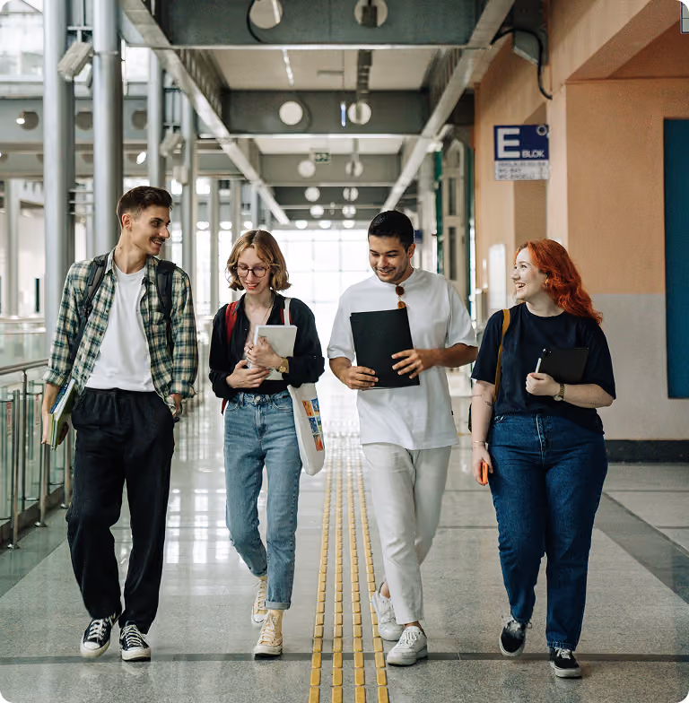 Four students walking on college building