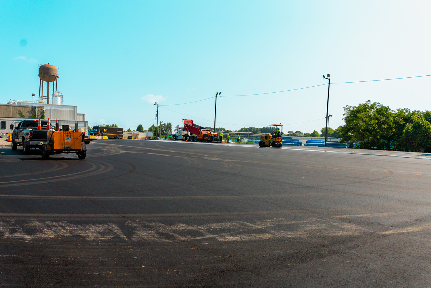 Dump truck delivering asphalt to the paving crew during lot resurfacing at National Pipe and Plastics, Colfax, NC