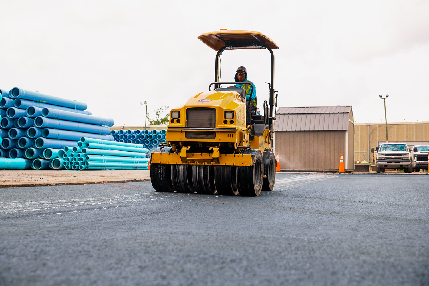 Lambeth Asphalt Services crew member operating a Weiler multi-tire pneumatic roller to compact fresh asphalt at National Pipe and Plastics, Colfax, NC