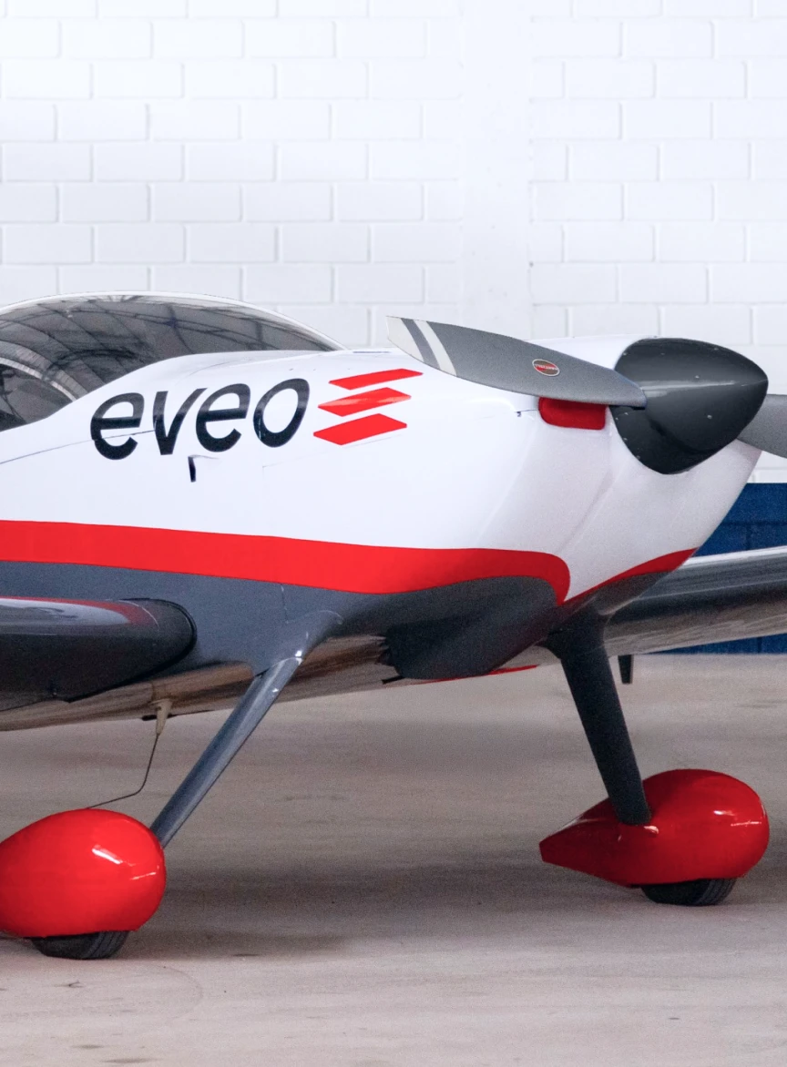 Aviao com a marca EVEO pintada na fuselagem, parado em um hangar