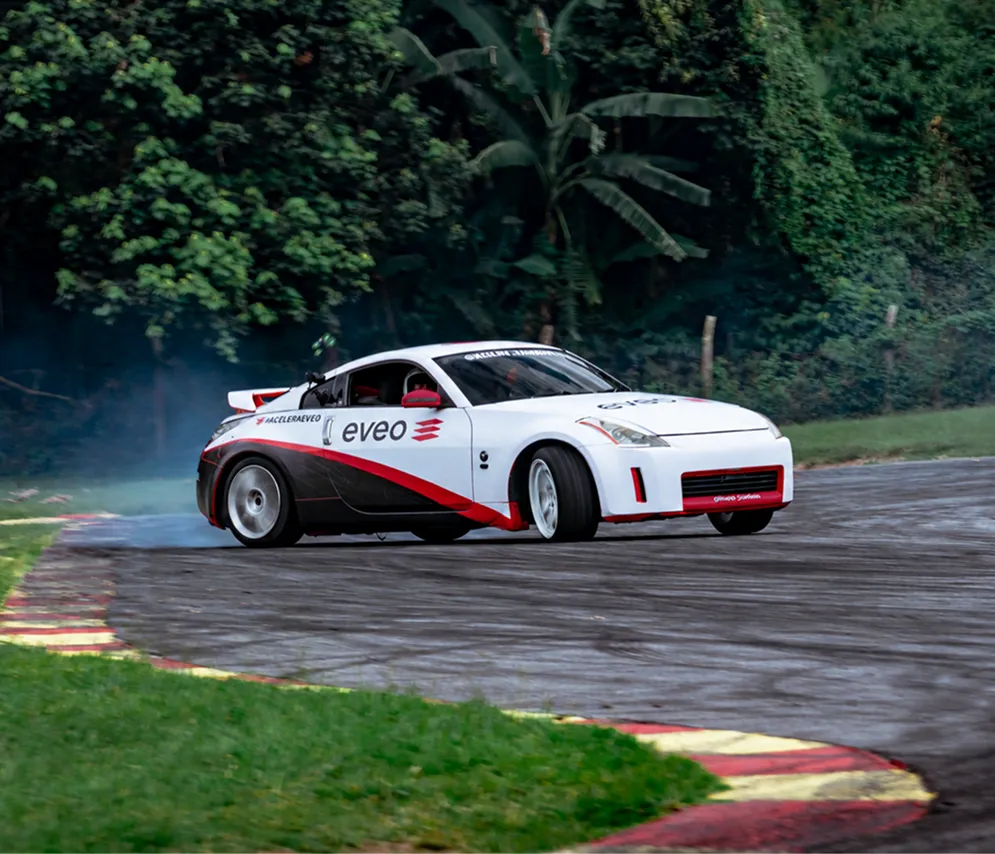 Carro de corrida com a marca EVEO derrapando em uma curva de autodromo
