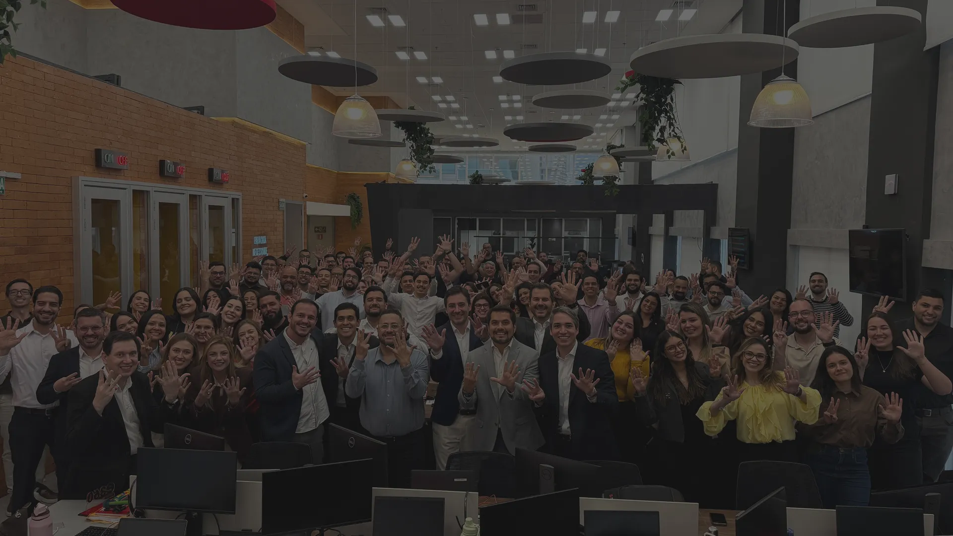 Time da EVEO reunido no escritorio, com as maos levantadas para a foto