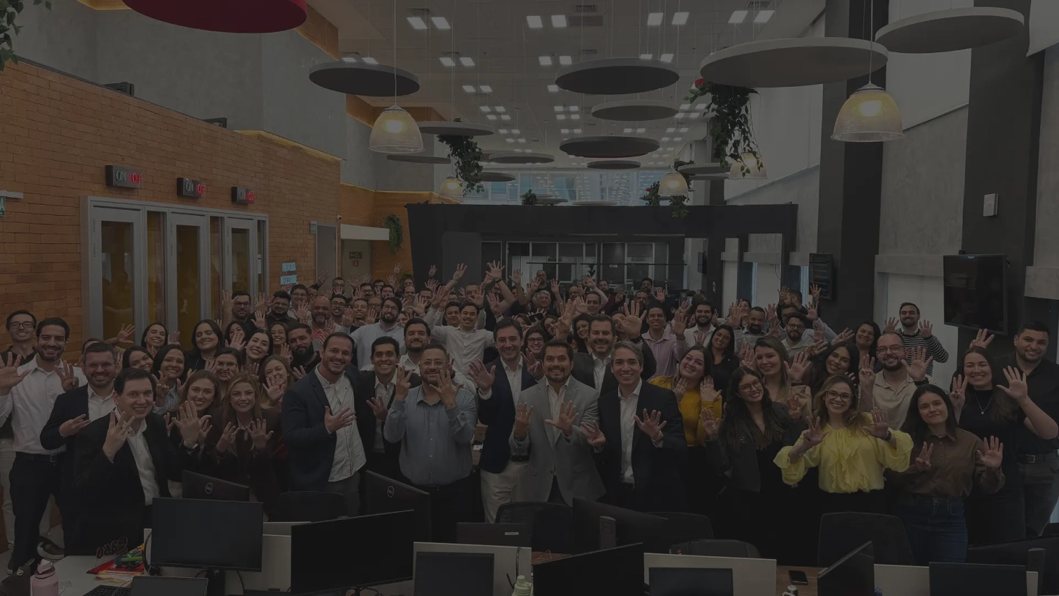 Time da EVEO reunido no escritorio, com as maos levantadas para a foto