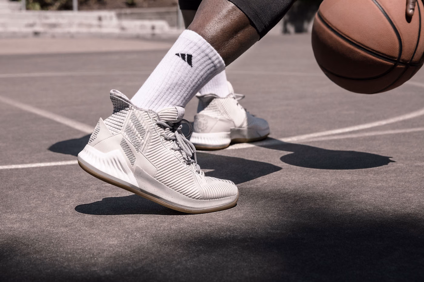Close-up on-model photography of the adidas D Rose 9 shoes mid-dribble, shot in Portland