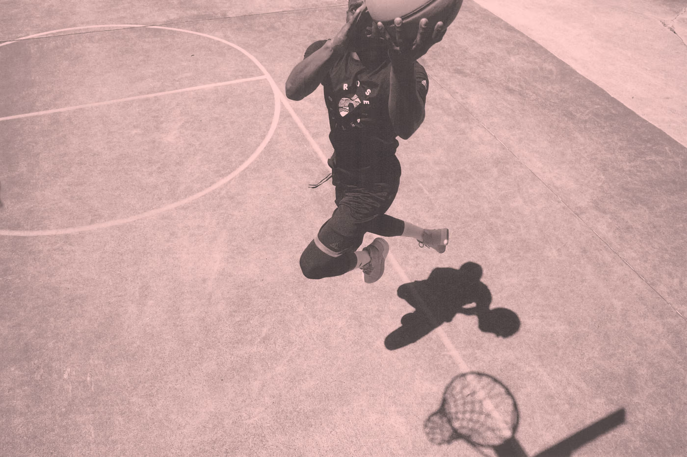 Overhead action shot of basketball player mid-air on an outdoor court, adidas D Rose 9 campaign