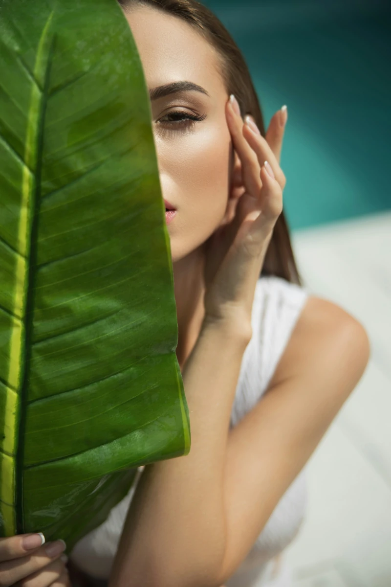 Women behind a large leaf