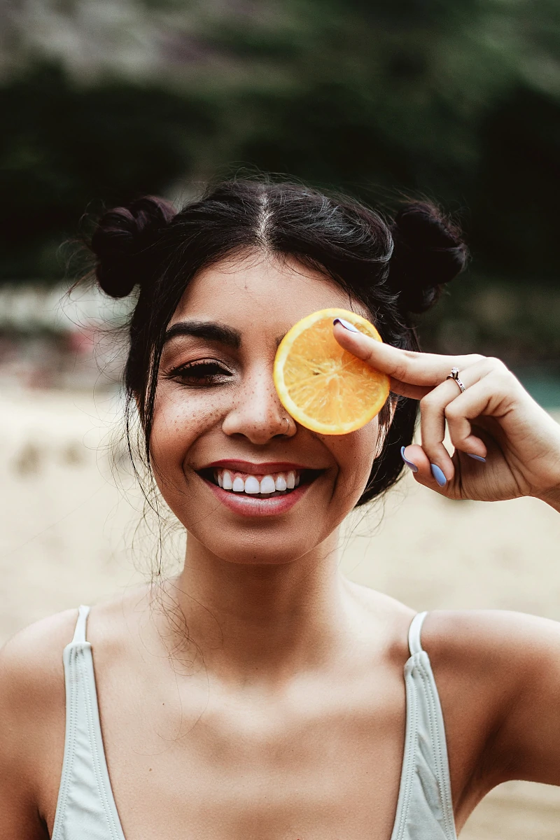 Women with an orange in front of eye