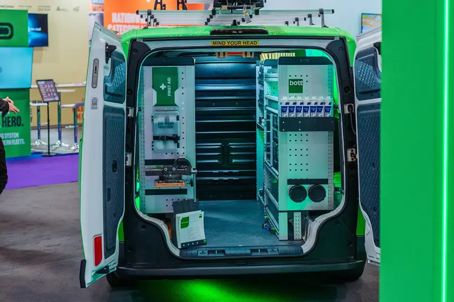 Suspended video screens and illuminated Bott and Van Guard branding above the exhibition stand