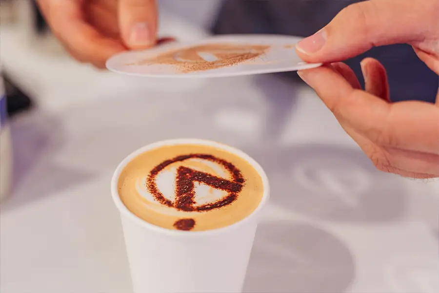Barista serving coffee from the branded hospitality counter on the Anaqua stand
