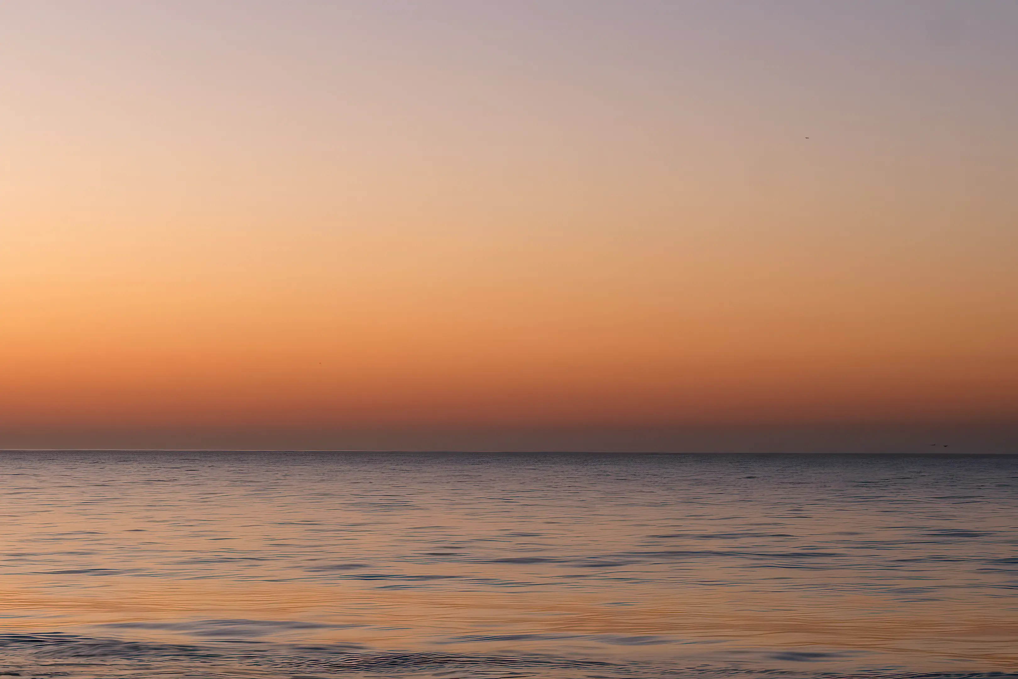 An image of a beautiful sunset over gentle ocean waves
