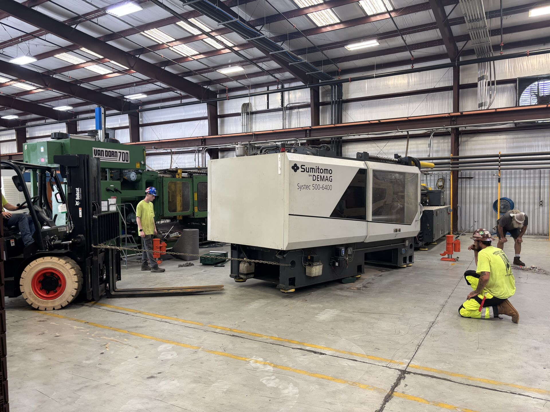 Forklift staging materials near a crane jobsite