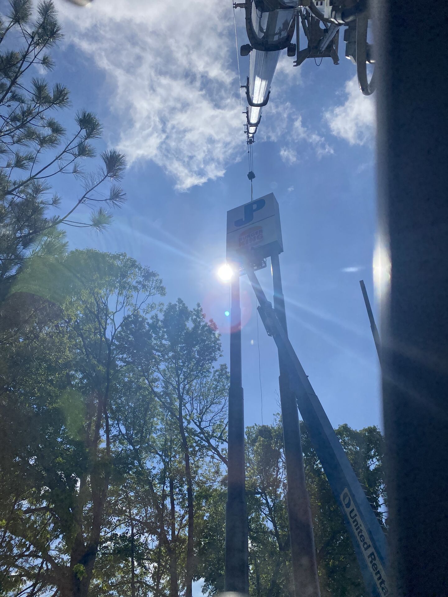 Crane boom extended in the yard with sun flare
