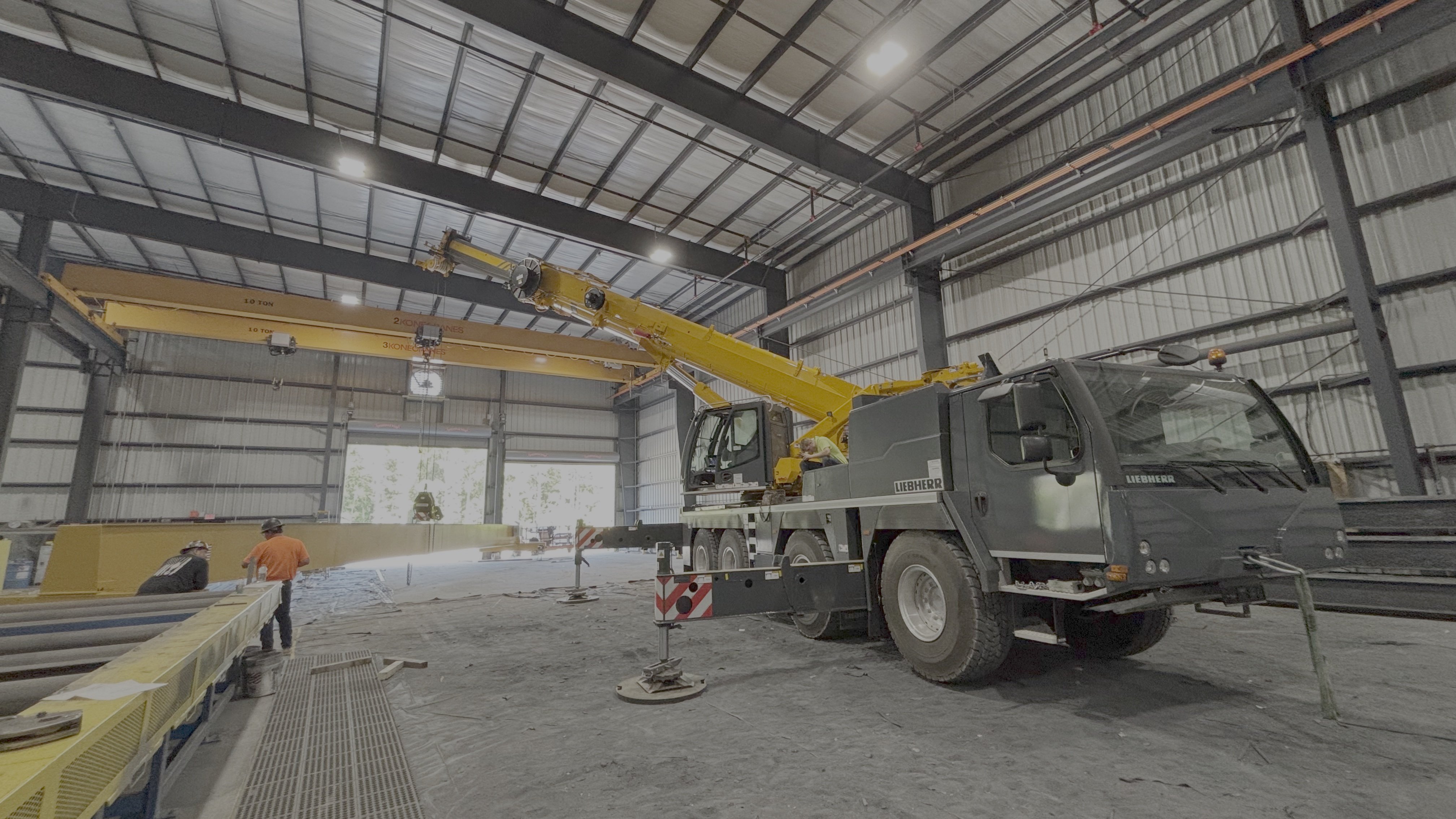 Liebherr all-terrain crane positioning steel inside a building under construction