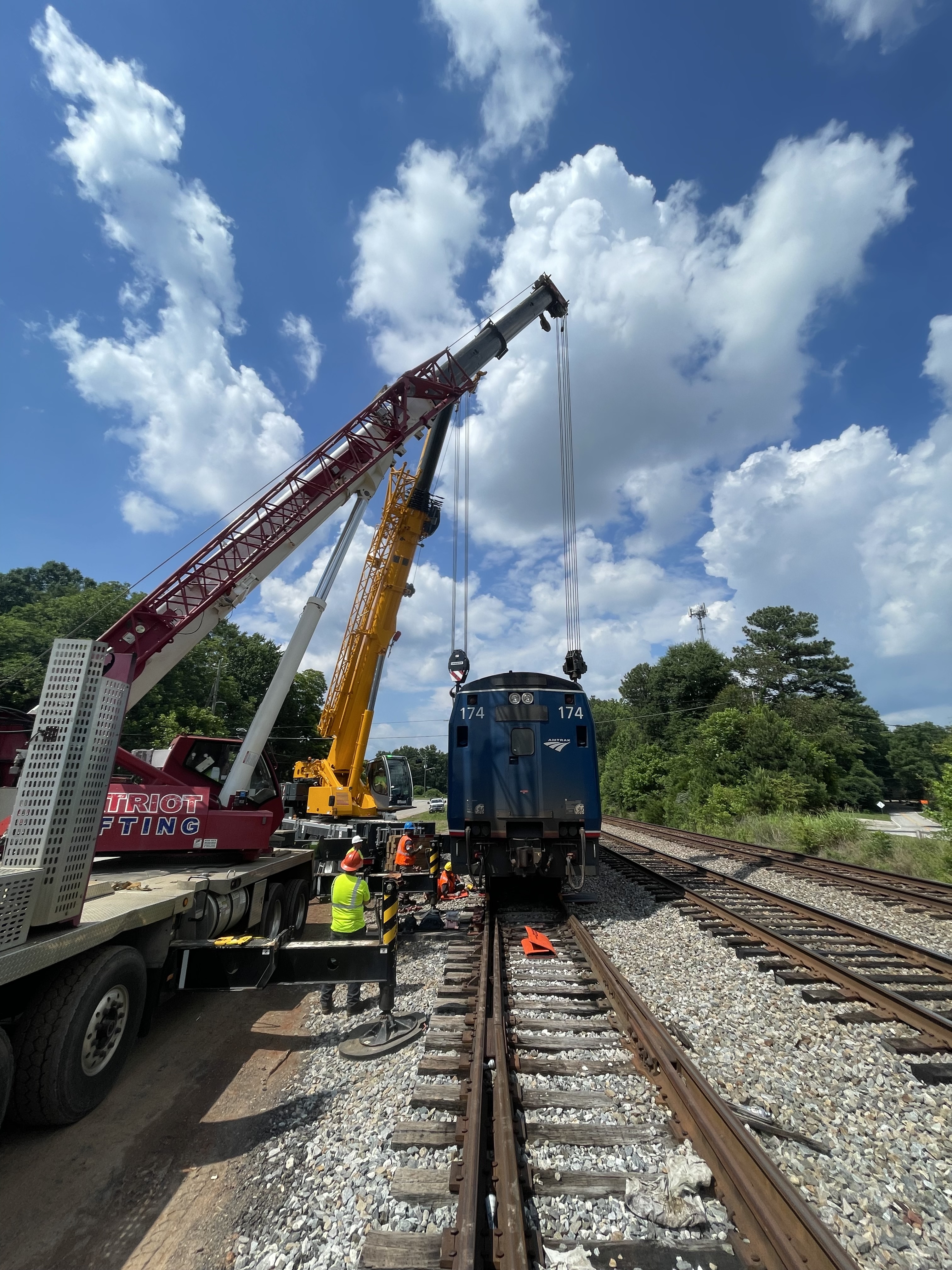 Patriot Lifting cranes rigged to locomotive 174 trackside during a rail repair lift
