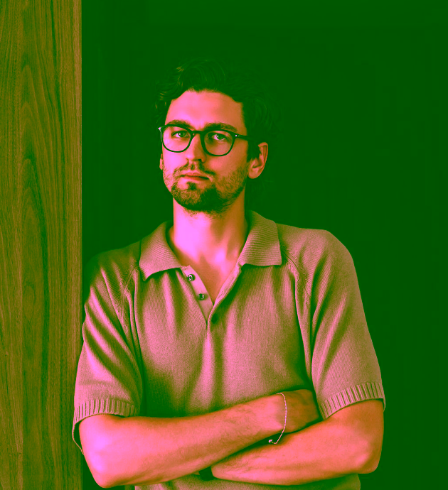Portrait of a young man in glasses with his arms crossed