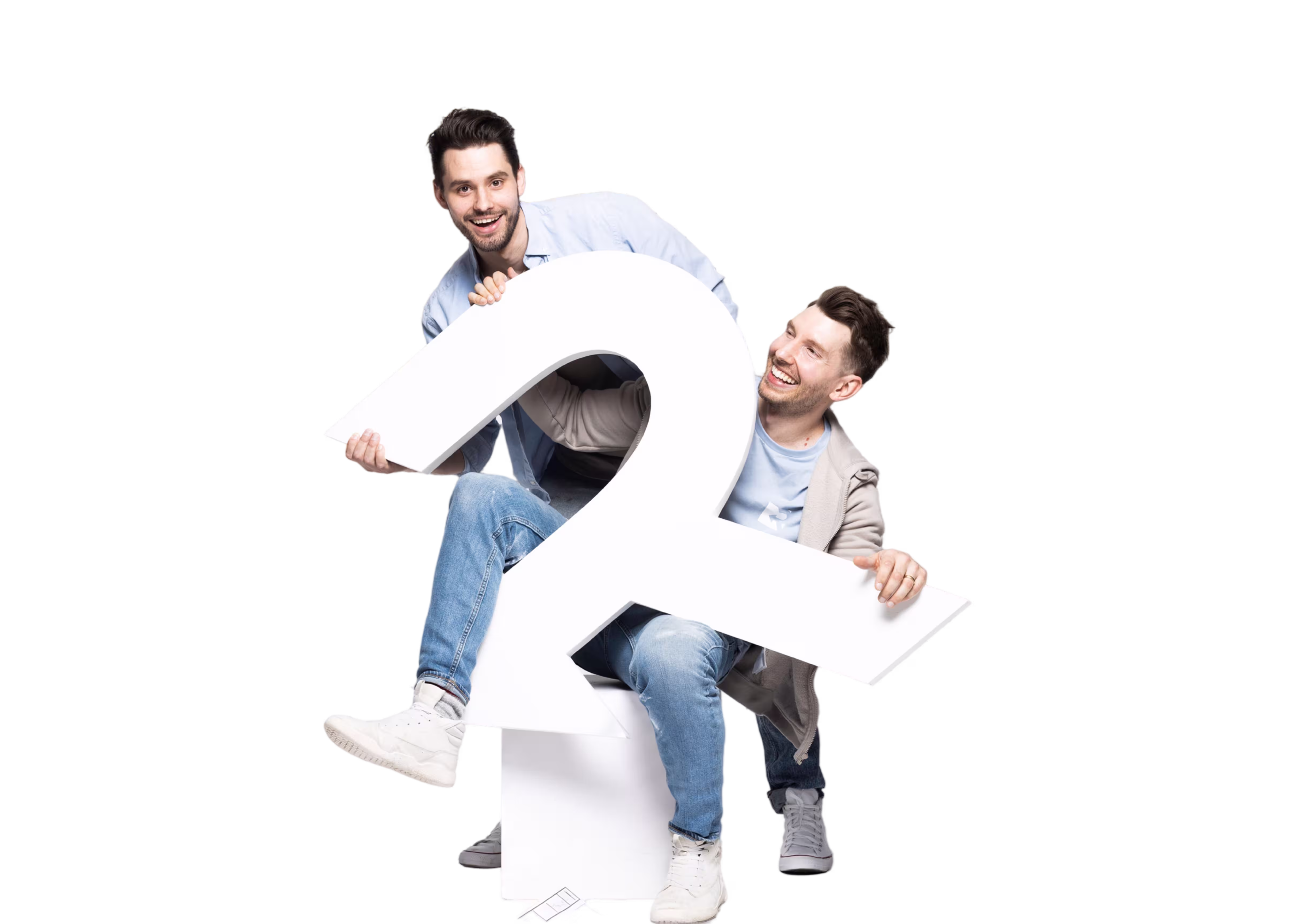 Two smiling men playfully hold a large white ampersand symbol together against a black background.